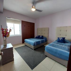 een slaapkamer met twee bedden en een raam bij Mayan Lake Horus in Acapulco +7 foto's
