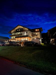 a large house with cars parked in front of it at Der Oswalderhof in Obertilliach