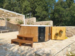 a wooden structure with a bench next to a wall at Villa Sasà in Fiskardo