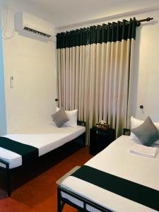 a room with two beds and a window at Stille Oase Inn in Matara