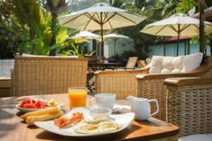 a breakfast of eggs and fruit on a wooden table at Mealea Resort in Kep