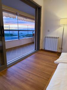 a bedroom with a large window with a view of the ocean at Hygge Living Santa Cruz Beachfront in Santa Cruz +21 photos