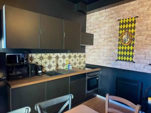 eine Küche mit blauen Schränken sowie einem Tisch und Stühlen in der Unterkunft Le Manoir des Sortilèges à Reims in Reims