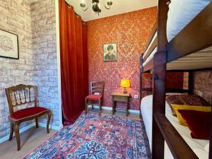 ein Schlafzimmer mit einem Etagenbett und einer roten Wand in der Unterkunft Le Manoir des Sortilèges à Reims in Reims
