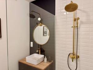 ein Badezimmer mit Waschbecken und Spiegel in der Unterkunft Le Manoir des Sortilèges à Reims in Reims