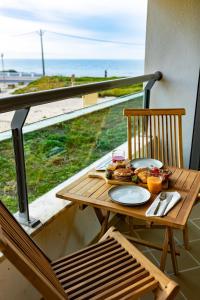 a table with a plate of food on a balcony at Hygge Living Santa Cruz Beachfront in Santa Cruz