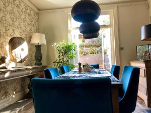 a dining room with a table and blue chairs at Saskia's Rooms in Winchester