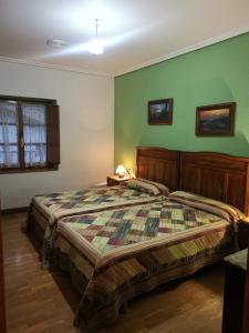 a bedroom with a bed and green walls at GURE TXOKO Casa Rural in Odériz