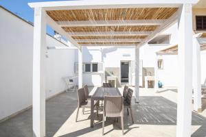 a dining room with a table and chairs on a patio at Solaris Apartments in Veglie