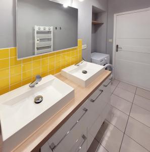 un bagno con due lavandini e uno specchio di Le Traict 1900 - Les Gîtes de la Côte d'Amour a Le Croisic