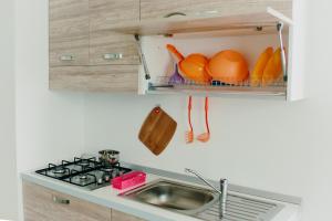 a kitchen with a sink and a shelf with eggs at Riviera 3 in Portoscuso