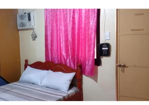 a bed with a pink curtain and a pink window at Golden Empress Hotel in Santa Barbara