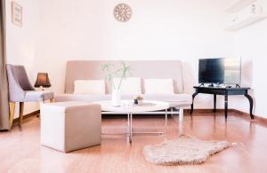 a living room with a white couch and a table at LaPlayaSuites 1st in Periyiálion