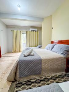una camera da letto con due letti e una finestra di Hotel Pousada Do Lago a Campo Maior