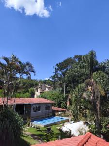 ein Haus mit einem Picknicktisch vor einem Berg in der Unterkunft Pousada Pitoresca Casa Amarela in Mairiporã