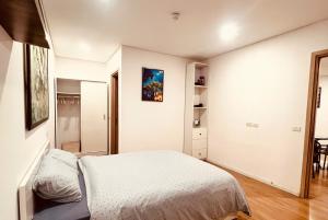 a white bedroom with a bed and a mirror at Emoi Mipec Riverside's Apt in Hanoi