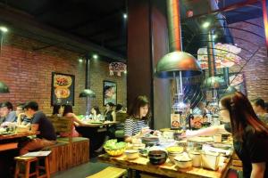 a group of people sitting at tables in a restaurant at Emoi Mipec Riverside's Apt in Hanoi +10 photos