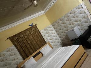 a bedroom with a bed with a wooden head board at Yessit Homestay in Abuja
