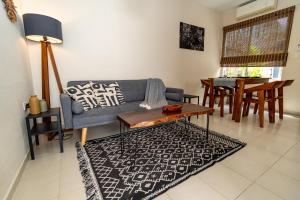 a living room with a couch and a table at Colorful Downtown House with Private Pool in Tulum