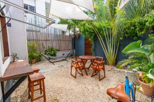 a patio with a table and chairs and plants at Colorful Downtown House with Private Pool in Tulum