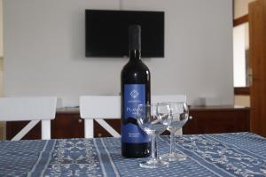 a bottle of wine sitting on a table with two wine glasses at Apartment Klementina FREE PARKING in Zagreb