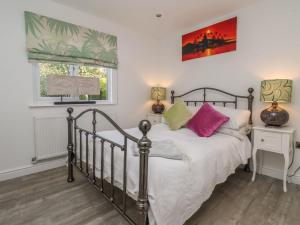 ein Schlafzimmer mit einem Bett und zwei Fenstern in der Unterkunft Ellesmere Cottage in Hornsea