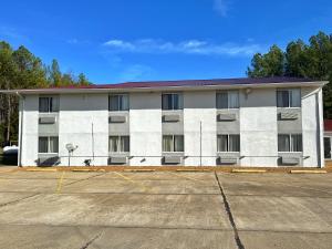 an empty parking lot in front of a white building at Lake Tree Inn & Suites in Woodland Hills