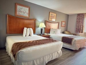 a hotel room with two beds and a couch at Lake Tree Inn & Suites in Woodland Hills