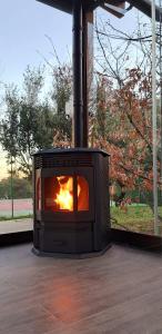 a fireplace sitting on a porch with a fire in it at El Chalet de los molinos in Los Molinos