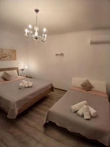 a bedroom with two beds and a chandelier at Melirito in Olympiada +9 photos