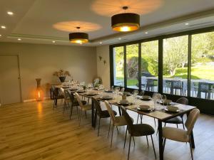 ein großer Raum mit einem langen Tisch und Stühlen in der Unterkunft La Grande Parenthèse Villa Golfe du Morbihan in Larmor-Baden