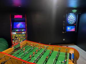 ein Spielezimmer mit einem Tisch und einer Spielkonsole in der Unterkunft La Grande Parenthèse Villa Golfe du Morbihan in Larmor-Baden