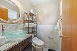 a bathroom with a sink and a toilet and a mirror at Perfect Group Stay 7 Beds Sleeps 15 Massage Chair 20 Min NYC in Bayonne +25 photos
