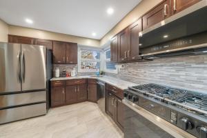 a kitchen with wooden cabinets and stainless steel appliances at Perfect Group Stay 7 Beds Sleeps 15 Massage Chair 20 Min NYC in Bayonne