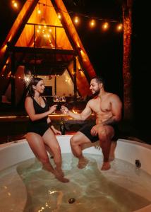 a man and a woman sitting in a bath tub at Cabaña Raices Habitat in Santo Domingo de los Colorados