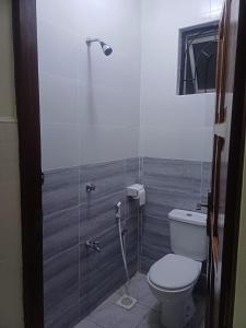 a bathroom with a toilet and a glass shower at Es Su Casa in Mombasa +8 photos