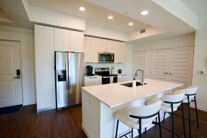 a kitchen with a white counter and a refrigerator at Ivory at Aviara East Pompano in Pompano Beach