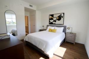a bedroom with a white bed and a mirror at Ivory at Aviara East Pompano in Pompano Beach +32 photos