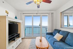 un soggiorno con un divano blu e una TV di Seychelles Unit 1205 a Panama City Beach