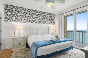 una camera da letto con un letto e un balcone con vista sull'oceano di Seychelles Unit 1205 a Panama City Beach Altre 21 foto