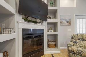 パナマ・シティ・ビーチにあるSalty Vibes - Panama City Beachのリビングルーム(暖炉、薄型テレビ付)