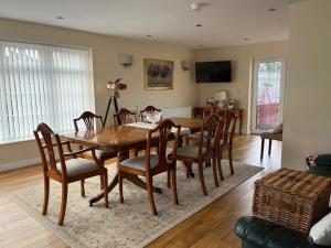 a dining room with a wooden table and chairs at PORTORA HOUSE- breakfast available pay host at property in Killyhevlin