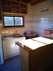 a kitchen with a counter and a sink and a window at Cabaña Tres Espinos Alto in Valdivia