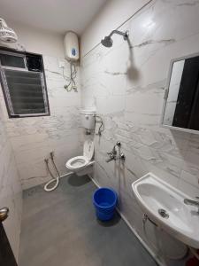 a white bathroom with a sink and a toilet at Creek View Studio Apartment in Mumbai