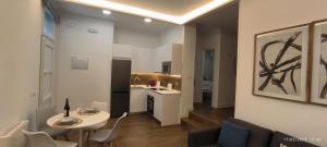 Una sala de estar con una mesa y una cocina. en El Mirador de El Retiro, en Madrid 9 fotos más