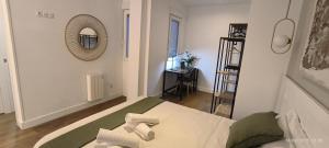 Una pequeña habitación con una cama y un espejo. en El Mirador de El Retiro, en Madrid