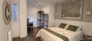 Un dormitorio con una cama blanca grande y una ventana en El Mirador de El Retiro, en Madrid