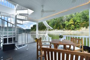 a porch with a table and chairs on a boat at TV Blue Tiny Houseboat at Lake Cumberland Marina in Nancy