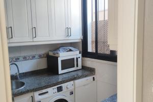 a kitchen with a microwave and a sink at Casa La Ribera 5 in Córdoba