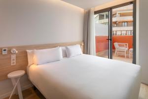 阿利坎特B&B HOTEL Alicante Centro的卧室里有一张白色的大床和一个阳台